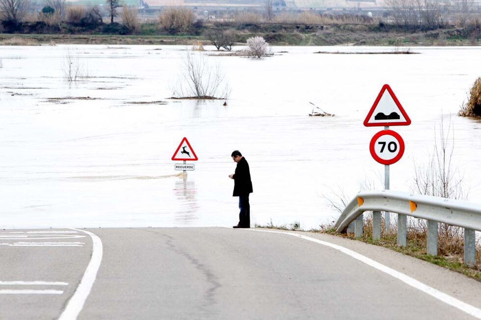 Un hombre en la carretera y el fondo del desbordamiento del Ebro
