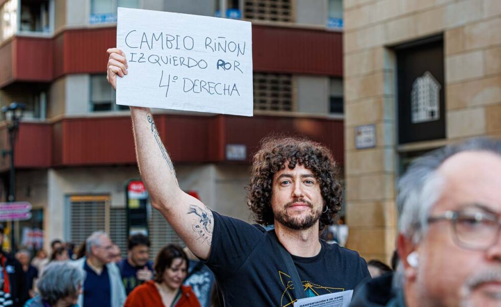 Un manifestante sujeta un cartel con el texto 