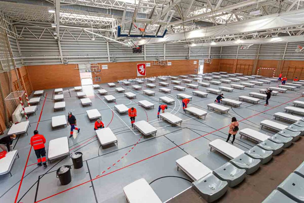 Personal habilitando un pabellón deportivo para la pandemia en Zaragoza