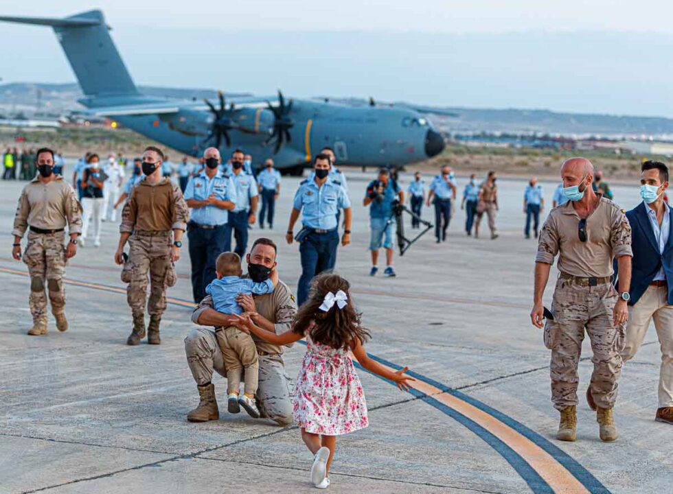 Militares bajando del avión y familiares abrazándolos