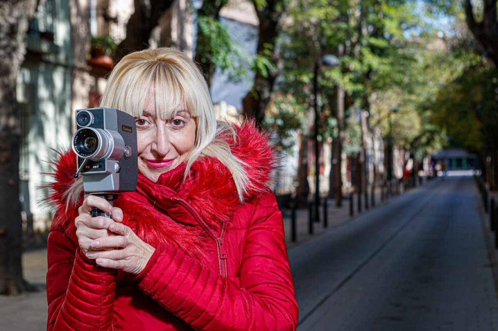 Fotografía de retrato de la cineasta Vicky Calavia con una cámara antigua en las calles de Zaragoza