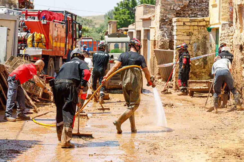 Operarios de bomberos limpian una zona dañada por la riada
